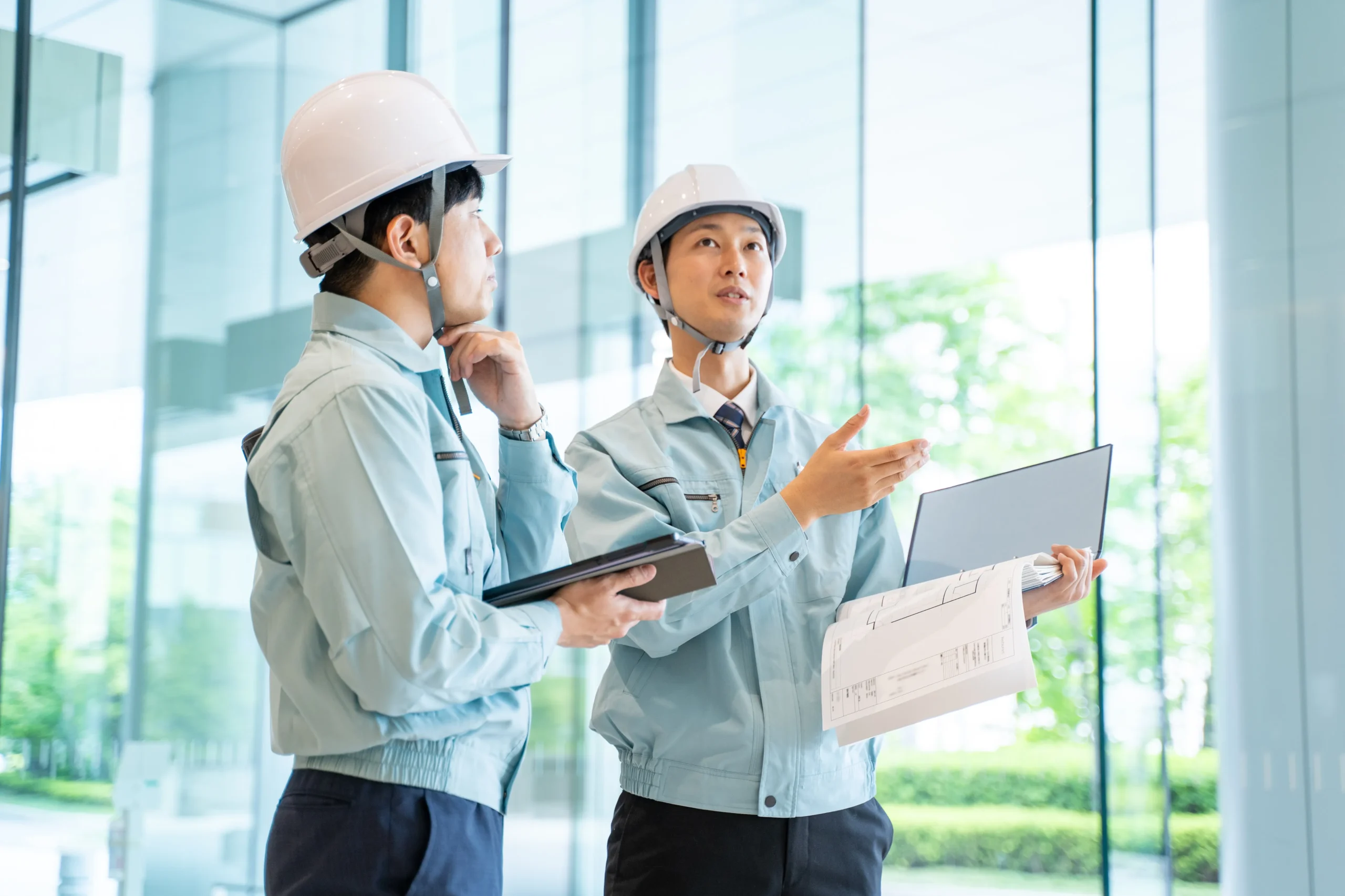 違法建築の是正工事に向けて設計図を確認しながら打ち合わせを行う作業員